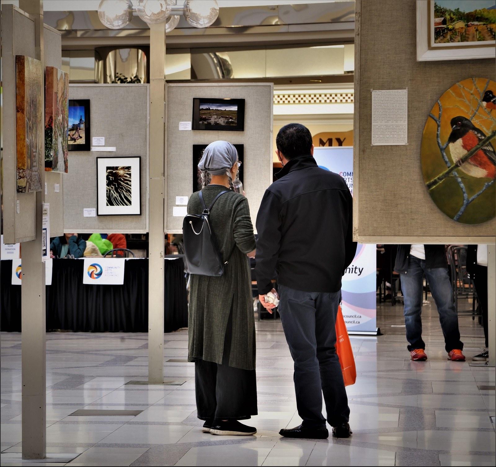 Visitors admire the framed works at our 2023 Shades of Fall Art Exhibition at Lansdowne Centre.
