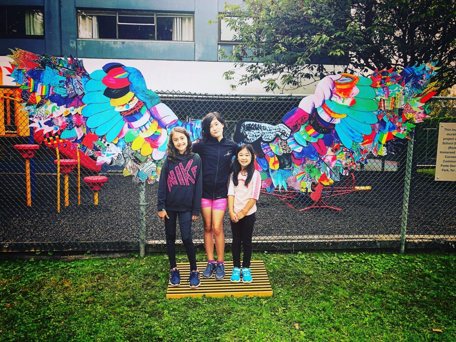 Students from The Arts Connection pose in front of the installed Wings Project from Reach to Teach.