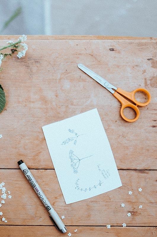 Drawing tools and a sketch on a wooden table at a CACR workshop